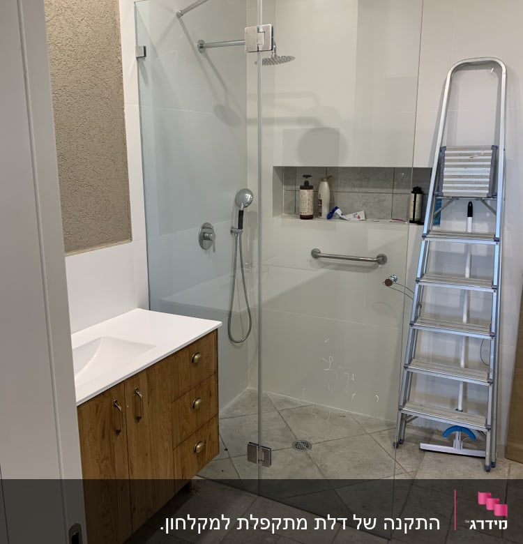 מקלחון זכוכית עם ראש מקלחת ומדף מוצרי טיפוח